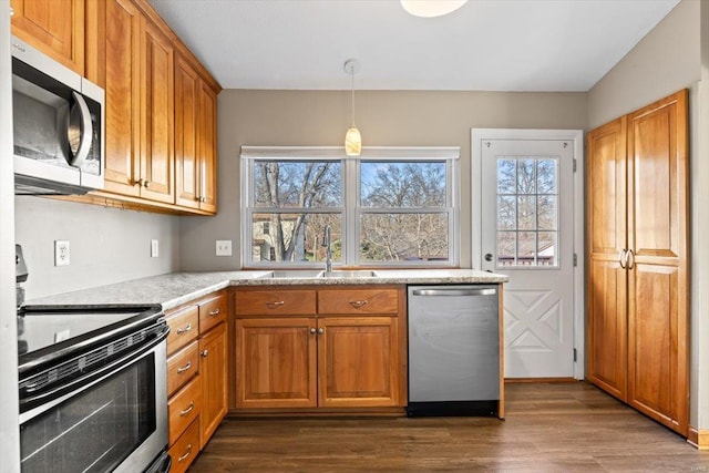 kitchen featuring decorative light fixtures, dark hardwood / wood-style flooring, stainless steel appliances, and sink