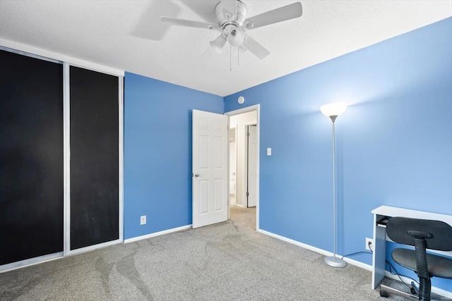 carpeted office featuring ceiling fan