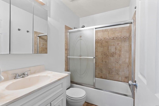 full bathroom featuring vanity, bath / shower combo with glass door, a textured ceiling, and toilet