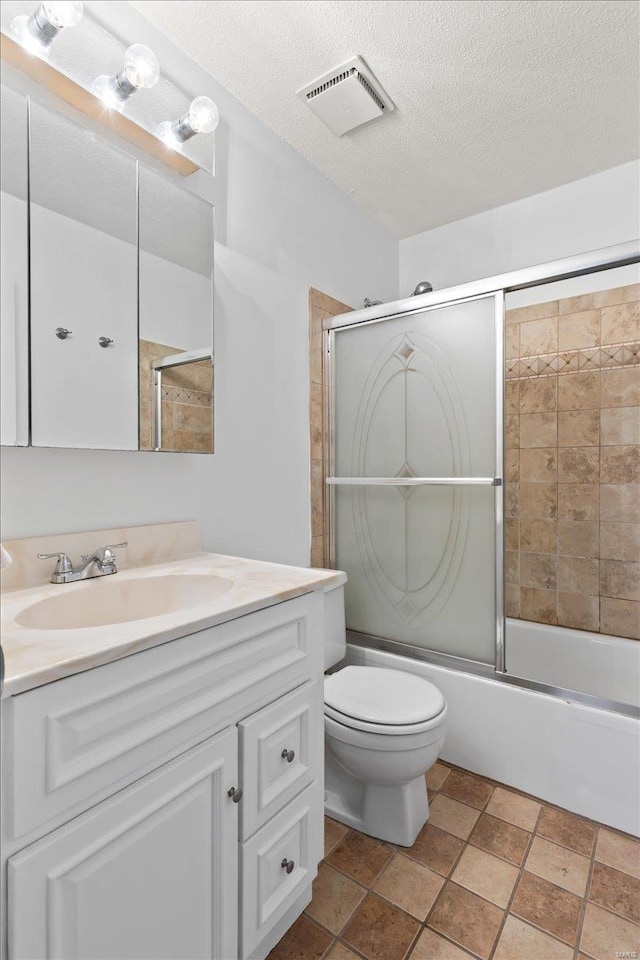 full bathroom with vanity, a textured ceiling, toilet, and enclosed tub / shower combo