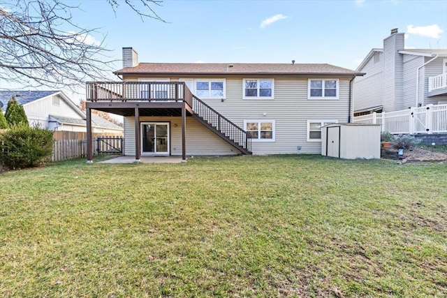 back of property with a lawn, a storage shed, and a deck