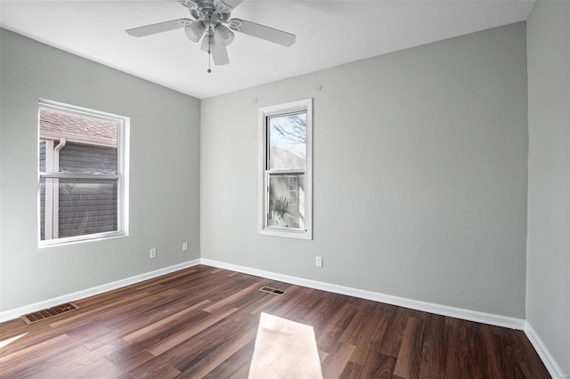 empty room with visible vents, baseboards, wood finished floors, and a ceiling fan