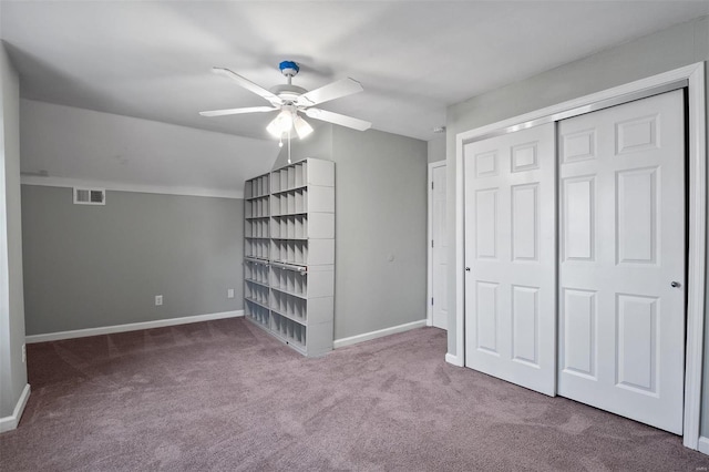 unfurnished bedroom with visible vents, baseboards, a closet, carpet flooring, and lofted ceiling