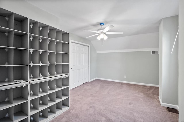 interior space featuring carpet, visible vents, baseboards, vaulted ceiling, and a closet