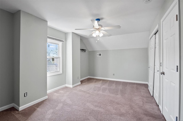 unfurnished bedroom with visible vents, baseboards, lofted ceiling, carpet floors, and a ceiling fan