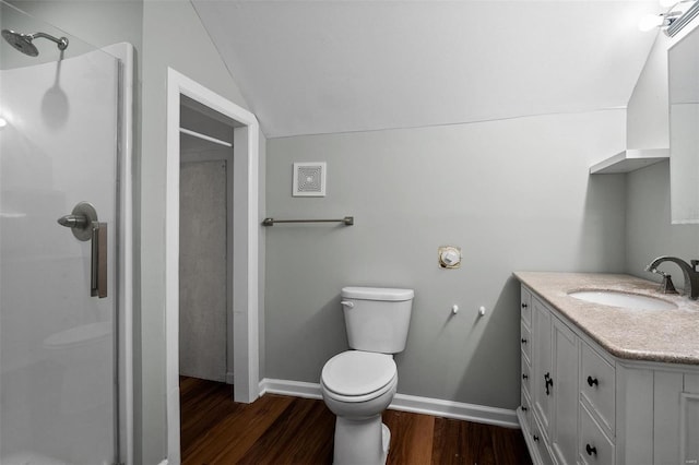 bathroom with vanity, wood finished floors, a stall shower, vaulted ceiling, and toilet