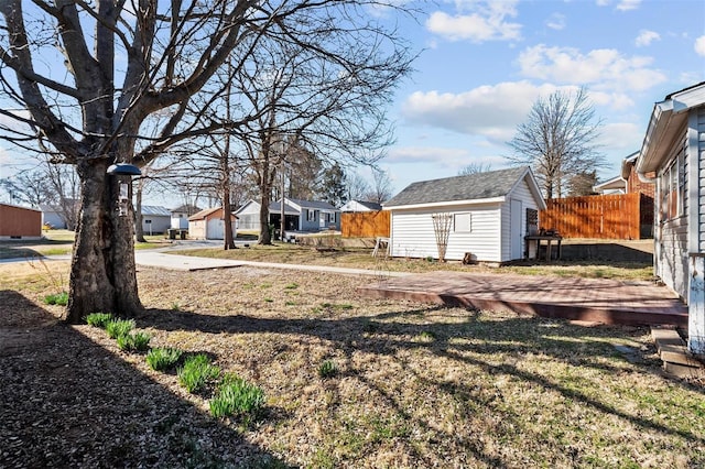 view of yard with a residential view, a storage unit, an outdoor structure, and fence