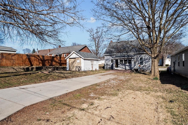 view of yard with an outbuilding, a storage unit, and fence