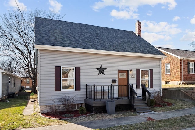 view of front of home featuring central AC, a chimney, and a shingled roof