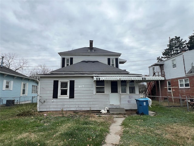 rear view of house featuring a yard