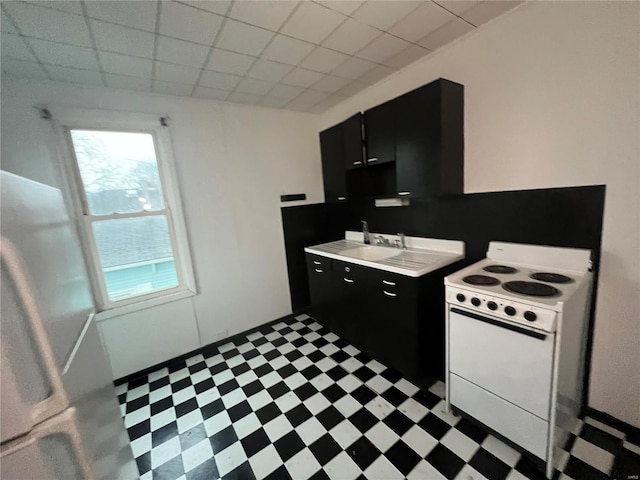 kitchen with a paneled ceiling, white electric stove, and sink