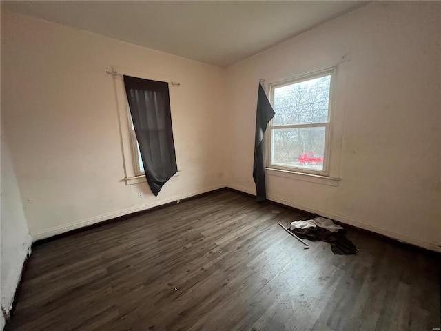 empty room with dark hardwood / wood-style flooring