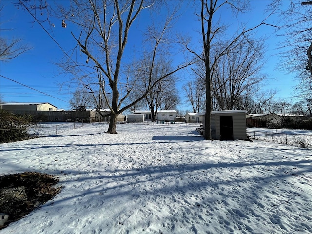 yard layered in snow featuring a storage shed