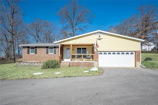 single story home featuring a porch, a garage, and a front yard