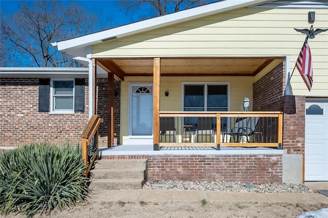 doorway to property featuring a porch and a garage