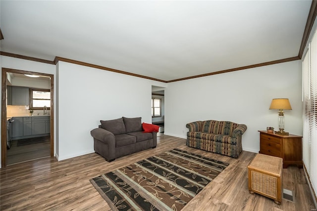 living room with crown molding, hardwood / wood-style flooring, and a wealth of natural light