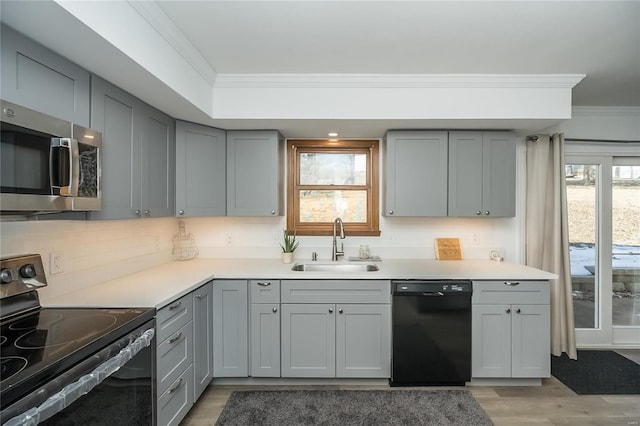 kitchen featuring gray cabinets, crown molding, sink, and black appliances