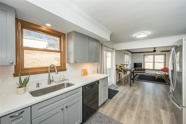 kitchen with sink, crown molding, stainless steel fridge, gray cabinetry, and black dishwasher