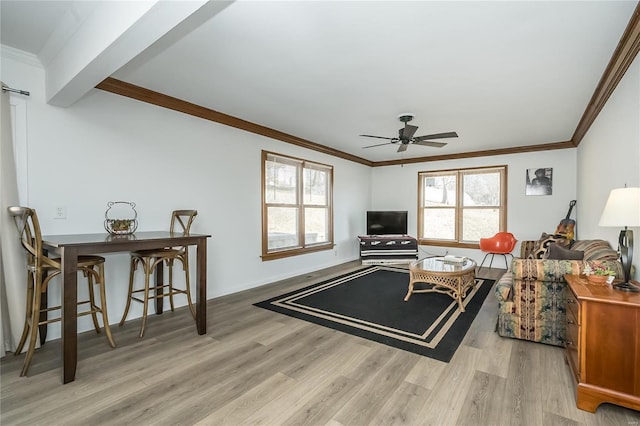 living room with ornamental molding, plenty of natural light, and light wood-type flooring