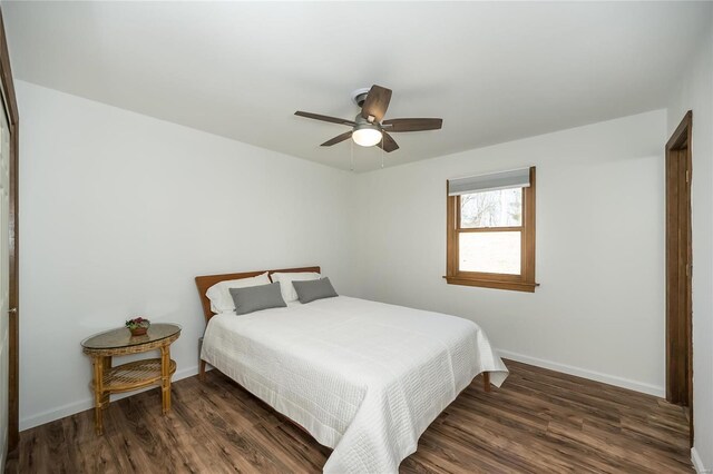 bedroom with dark hardwood / wood-style floors and ceiling fan