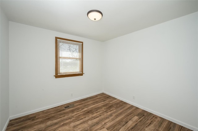 spare room with dark hardwood / wood-style flooring