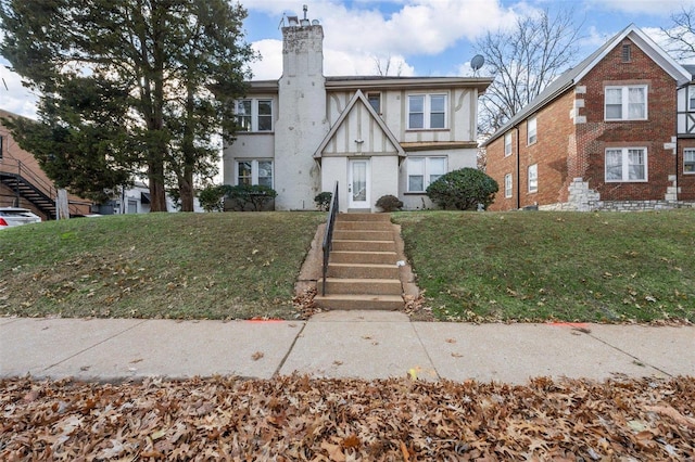 tudor-style house featuring a front yard