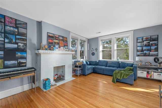 living room featuring a brick fireplace and hardwood / wood-style floors