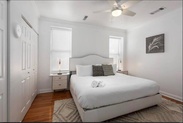 bedroom featuring ceiling fan, ornamental molding, a closet, and dark hardwood / wood-style floors