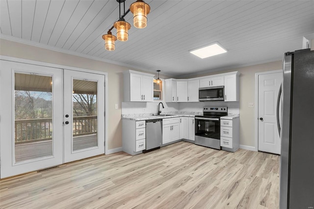 kitchen with white cabinets, french doors, stainless steel appliances, and hanging light fixtures