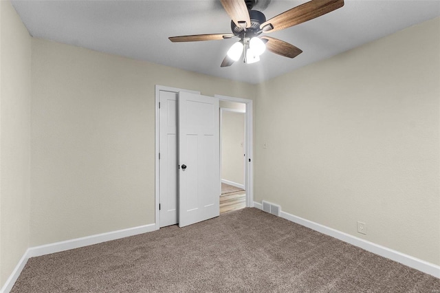 unfurnished bedroom with ceiling fan, a closet, and carpet floors