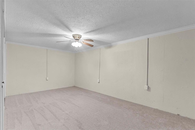 carpeted spare room featuring ceiling fan, ornamental molding, and a textured ceiling