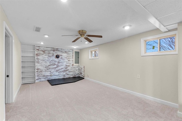 unfurnished bedroom with ceiling fan, light carpet, and a textured ceiling