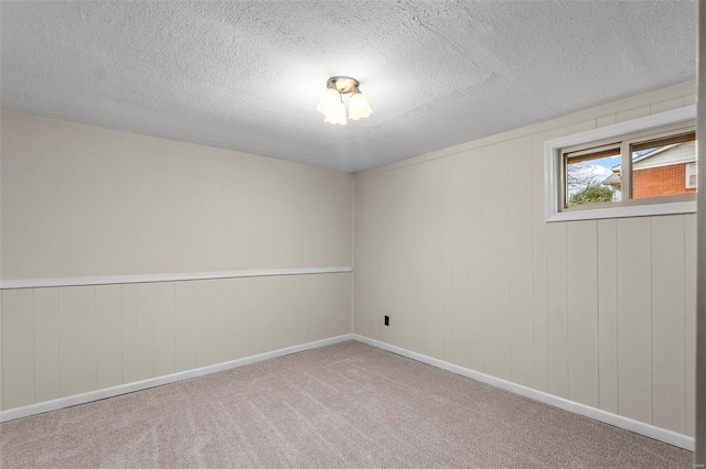 carpeted empty room with a textured ceiling