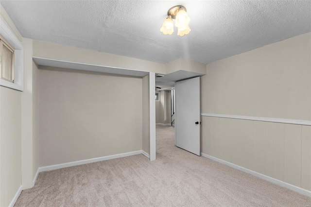 basement with light colored carpet and a textured ceiling