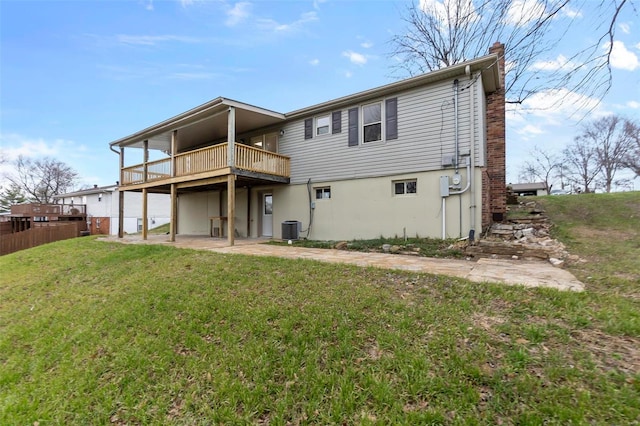 back of property with central AC unit, a deck, and a yard