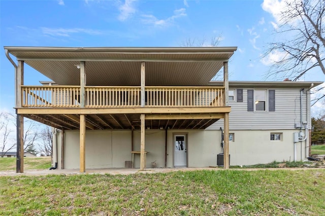 rear view of property featuring a yard and a wooden deck