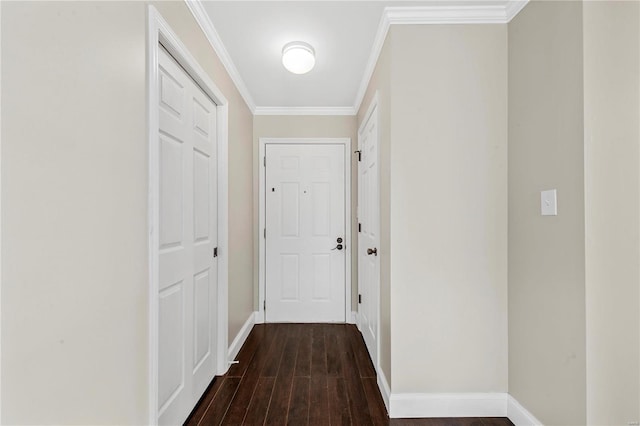 entryway with dark wood-style floors, ornamental molding, and baseboards