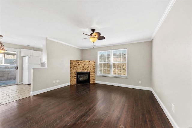 unfurnished living room featuring ornamental molding, a fireplace, baseboards, and wood finished floors