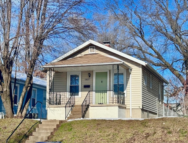 bungalow with covered porch and a front yard