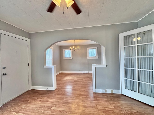 entrance foyer featuring light wood-type flooring, ceiling fan with notable chandelier, and ornamental molding