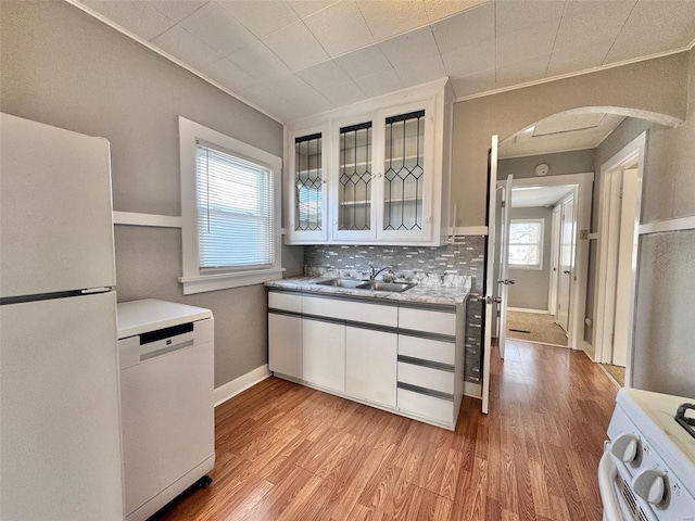 kitchen featuring backsplash, sink, white appliances, white cabinetry, and ornamental molding