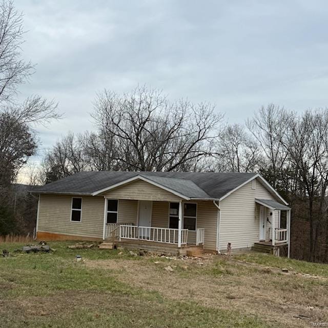 single story home with a porch and a front lawn