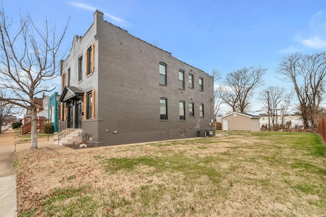 view of home's exterior with a lawn and central AC unit