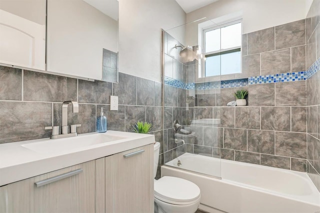 full bathroom with tasteful backsplash, vanity, tiled shower / bath combo, tile walls, and toilet