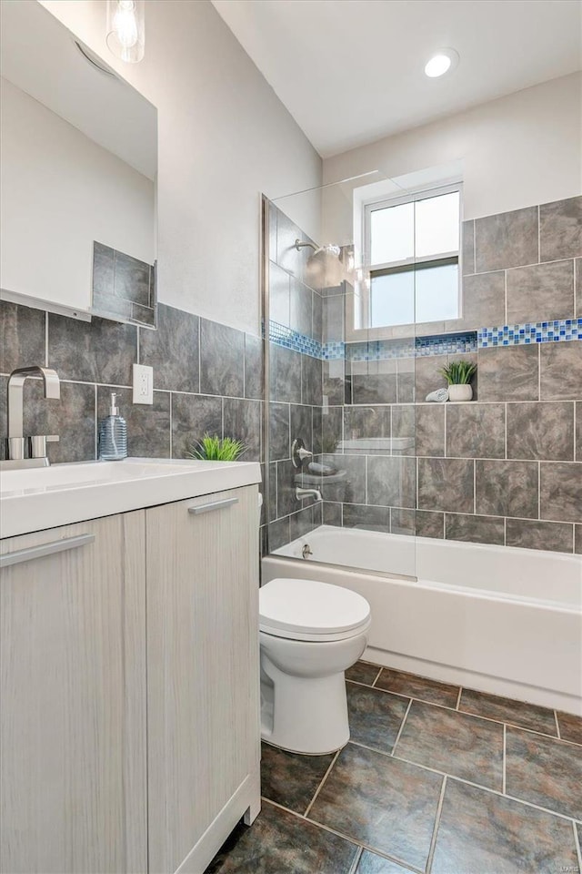 full bathroom with vanity, toilet, and tiled shower / bath