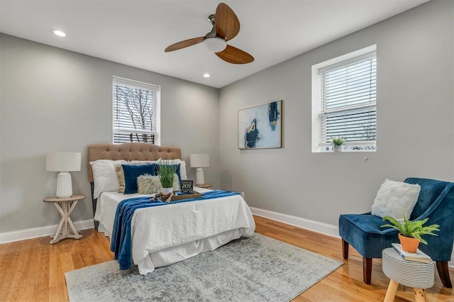 bedroom featuring multiple windows, hardwood / wood-style floors, and ceiling fan