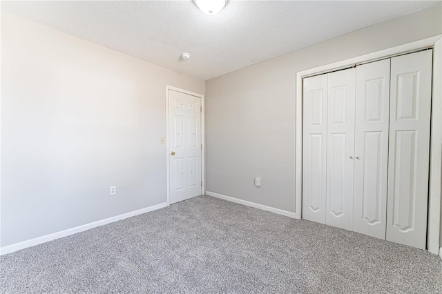 unfurnished bedroom with a closet, a textured ceiling, and carpet flooring