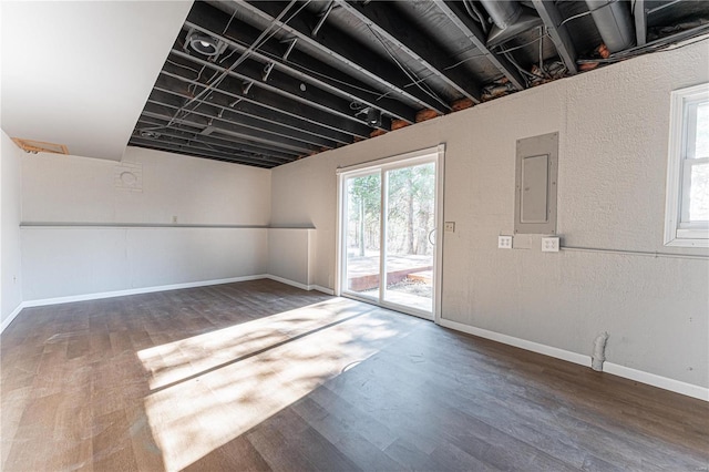 basement featuring dark hardwood / wood-style floors and electric panel