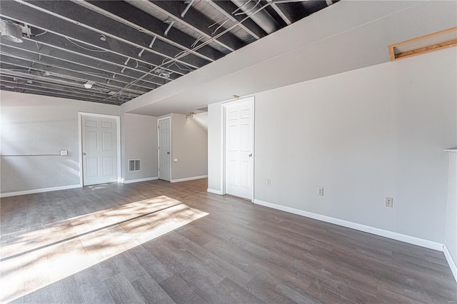 basement with dark hardwood / wood-style floors