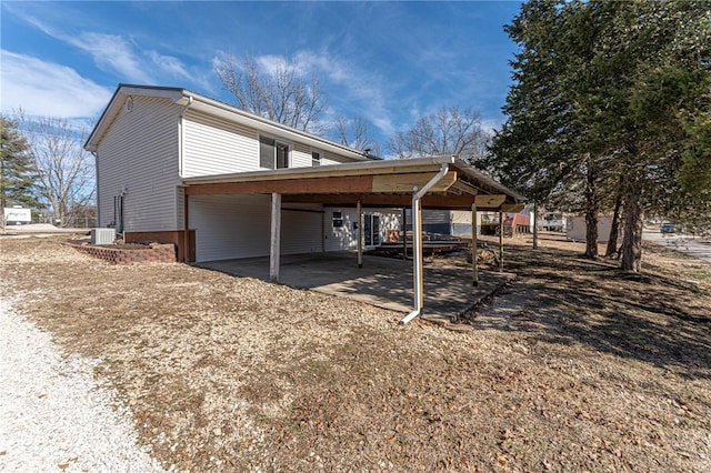 view of side of home with cooling unit and a carport